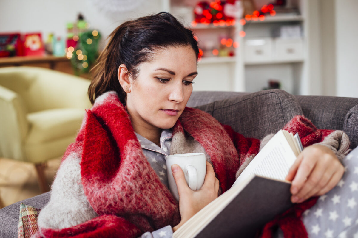 Frau auf der Couch mit Buch